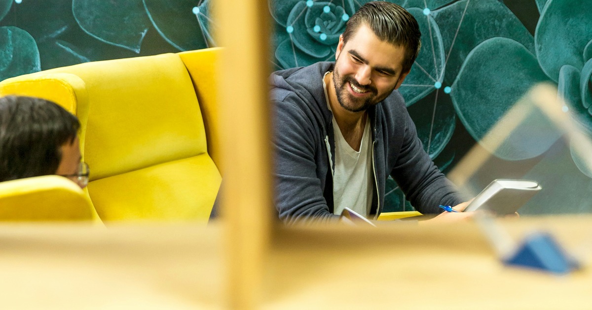 Plano arquitectónico desplegado sobre mesa de trabajo con herramientas de diseño, representando la planificación estructurada de sistemas complejos