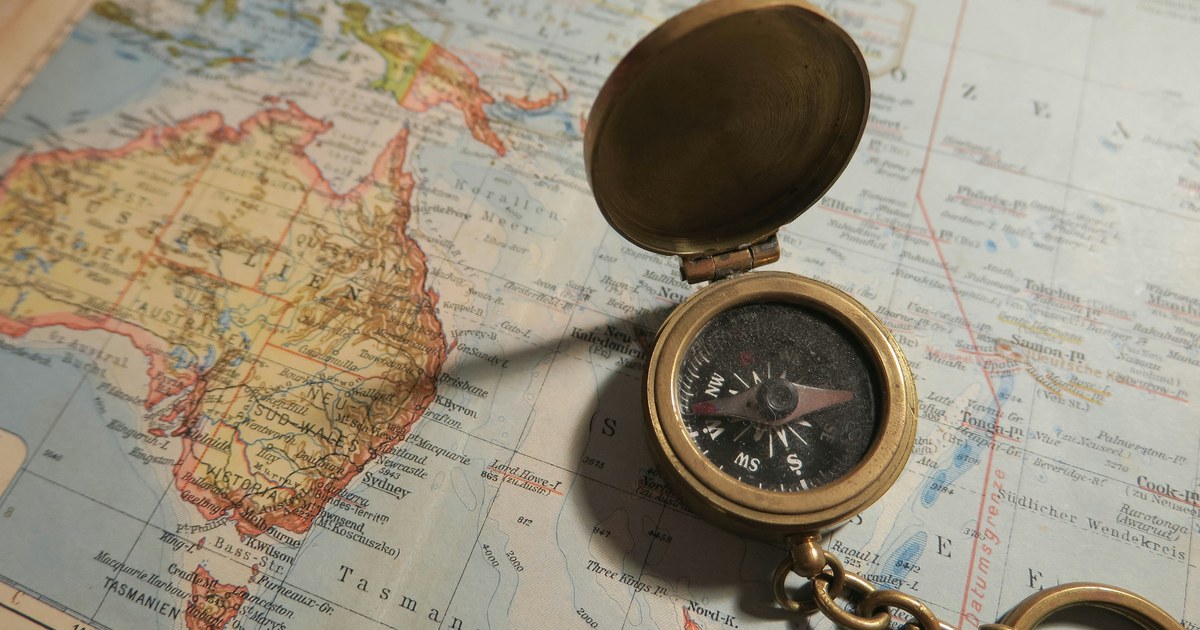 Brújula de navegación sobre un mapa geográfico desplegado, con la aguja señalando el norte magnético como referencia de dirección estratégica